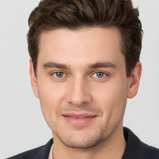 Joyful white young-adult male with short  brown hair and brown eyes