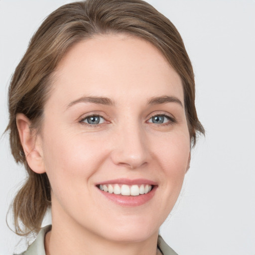 Joyful white young-adult female with medium  brown hair and grey eyes