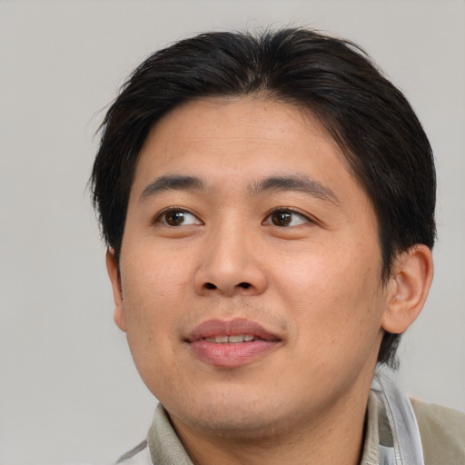 Joyful asian young-adult male with short  brown hair and brown eyes