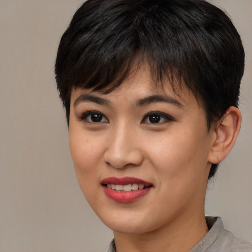 Joyful asian young-adult female with short  brown hair and brown eyes