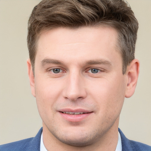 Joyful white young-adult male with short  brown hair and grey eyes