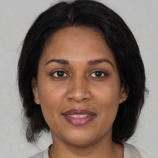 Joyful black adult female with medium  brown hair and brown eyes
