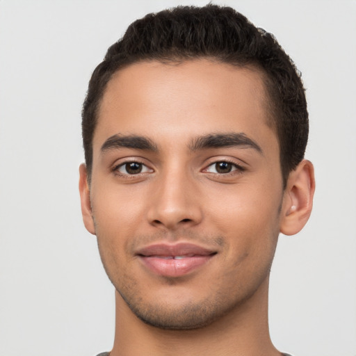 Joyful latino young-adult male with short  black hair and brown eyes