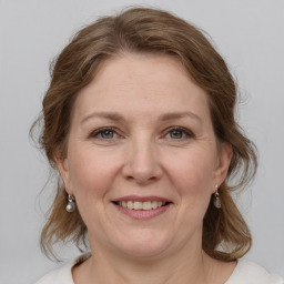 Joyful white adult female with medium  brown hair and grey eyes