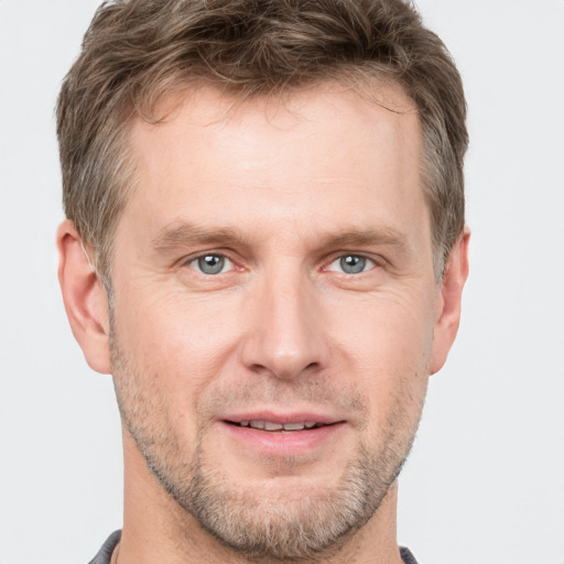 Joyful white adult male with short  brown hair and grey eyes