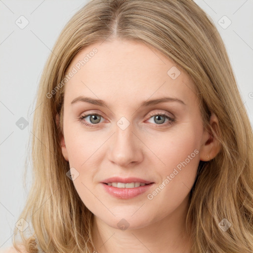 Joyful white young-adult female with long  brown hair and blue eyes