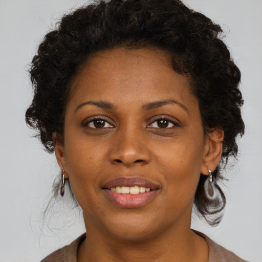 Joyful black young-adult female with medium  brown hair and brown eyes