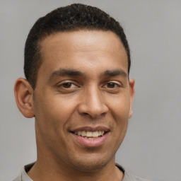 Joyful latino young-adult male with short  brown hair and brown eyes