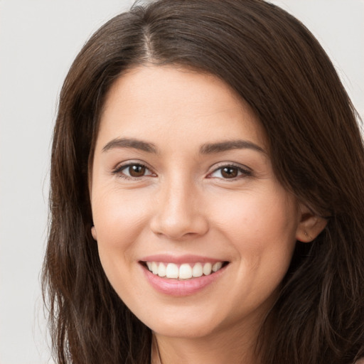 Joyful white young-adult female with long  brown hair and brown eyes