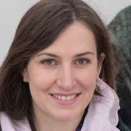 Joyful white young-adult female with medium  brown hair and grey eyes