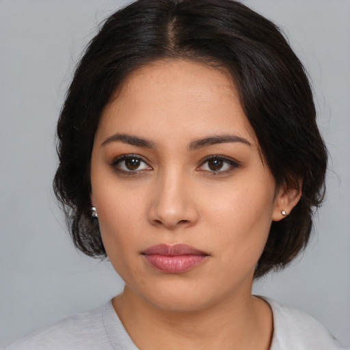 Joyful latino young-adult female with medium  black hair and brown eyes