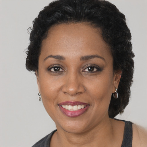 Joyful black adult female with short  black hair and brown eyes