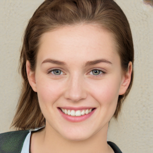 Joyful white young-adult female with medium  brown hair and blue eyes