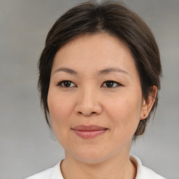 Joyful asian adult female with medium  brown hair and brown eyes