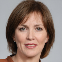 Joyful white adult female with medium  brown hair and grey eyes