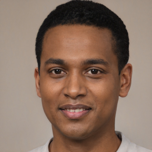 Joyful black young-adult male with short  black hair and brown eyes