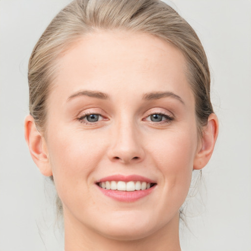 Joyful white young-adult female with medium  brown hair and blue eyes