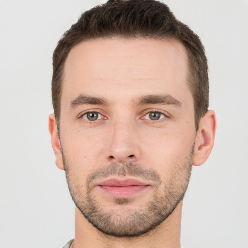 Joyful white young-adult male with short  brown hair and grey eyes