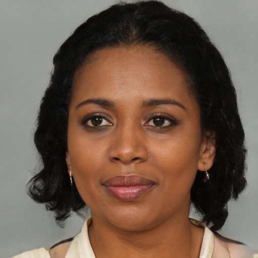 Joyful black adult female with medium  brown hair and brown eyes