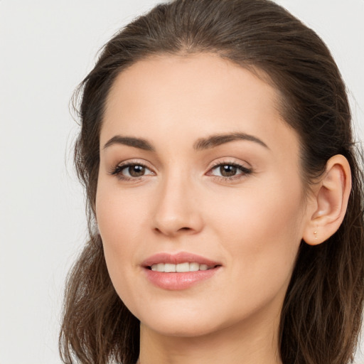 Joyful white young-adult female with long  brown hair and brown eyes