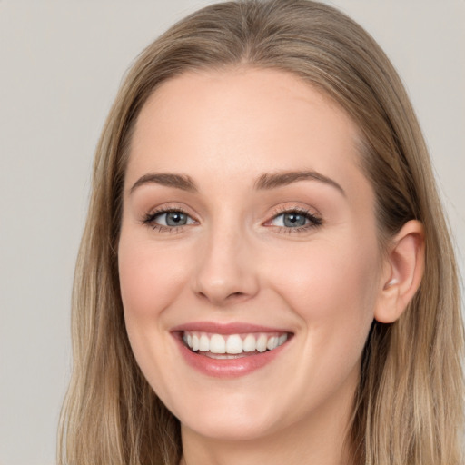 Joyful white young-adult female with long  brown hair and blue eyes