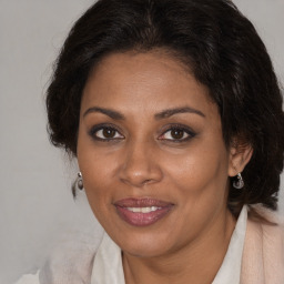 Joyful black adult female with medium  brown hair and brown eyes