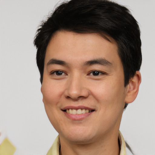 Joyful asian young-adult male with short  brown hair and brown eyes
