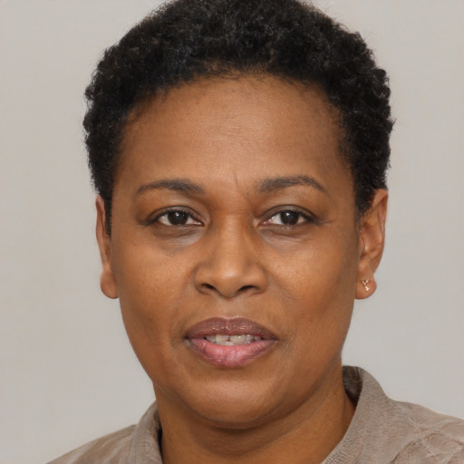 Joyful black adult female with short  black hair and brown eyes