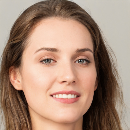 Joyful white young-adult female with long  brown hair and blue eyes