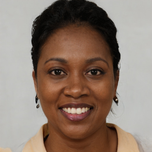 Joyful black young-adult female with short  black hair and brown eyes