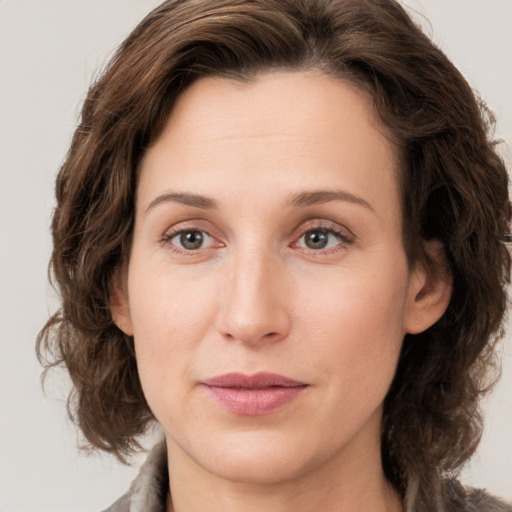 Joyful white young-adult female with medium  brown hair and green eyes