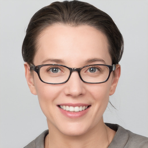 Joyful white young-adult female with medium  brown hair and grey eyes