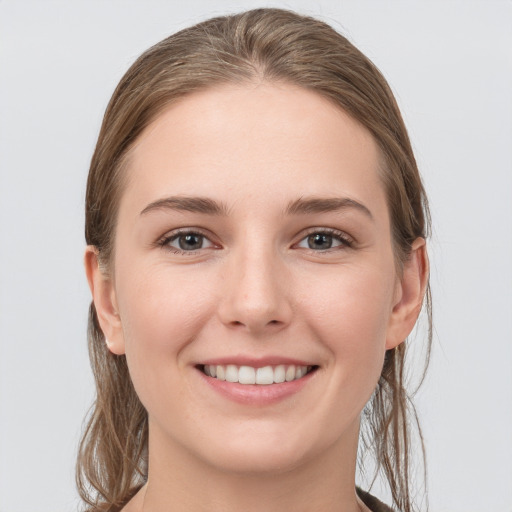 Joyful white young-adult female with long  brown hair and grey eyes