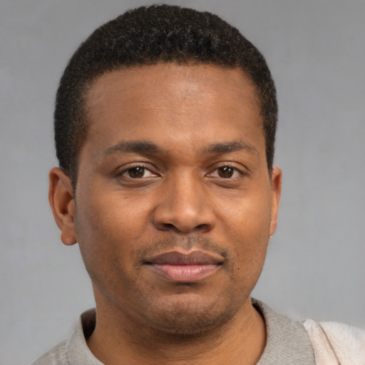 Joyful black young-adult male with short  brown hair and brown eyes