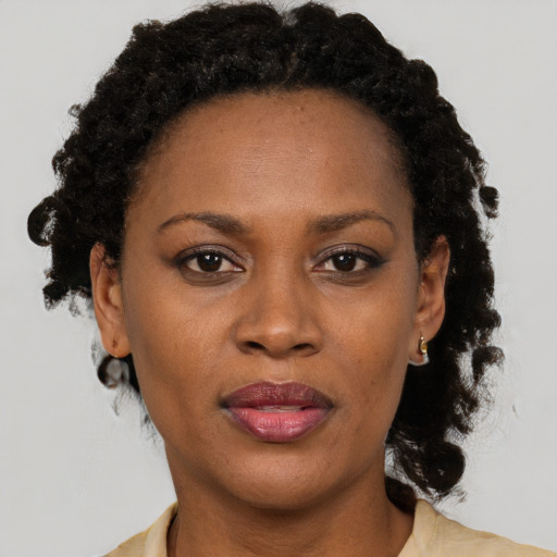 Joyful black adult female with medium  black hair and brown eyes