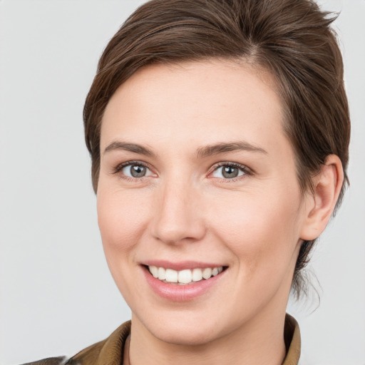 Joyful white young-adult female with medium  brown hair and grey eyes