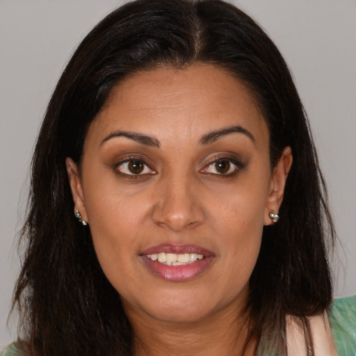 Joyful black young-adult female with long  brown hair and brown eyes