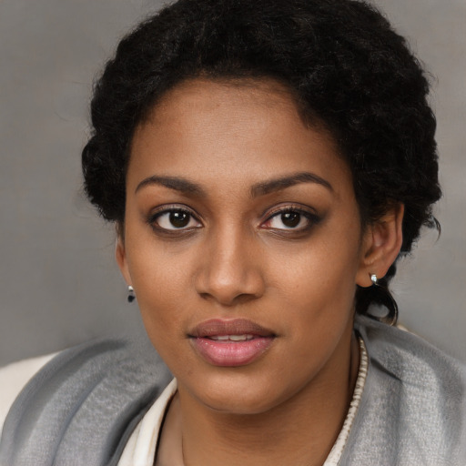 Joyful black young-adult female with short  black hair and brown eyes