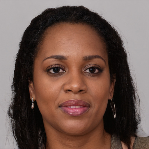 Joyful black adult female with long  brown hair and brown eyes