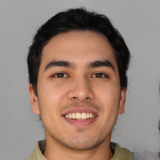 Joyful latino young-adult male with short  black hair and brown eyes