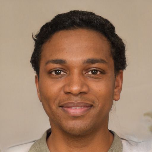 Joyful black young-adult male with short  black hair and brown eyes