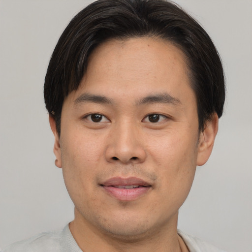 Joyful asian young-adult male with short  brown hair and brown eyes