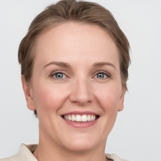 Joyful white young-adult female with short  brown hair and grey eyes