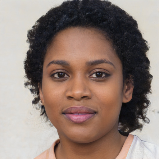 Joyful black young-adult female with long  black hair and brown eyes