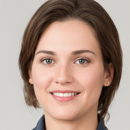 Joyful white young-adult female with medium  brown hair and grey eyes