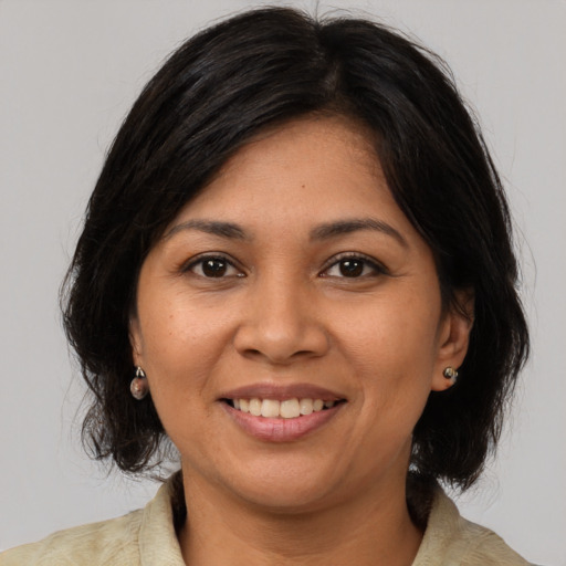 Joyful latino adult female with medium  brown hair and brown eyes