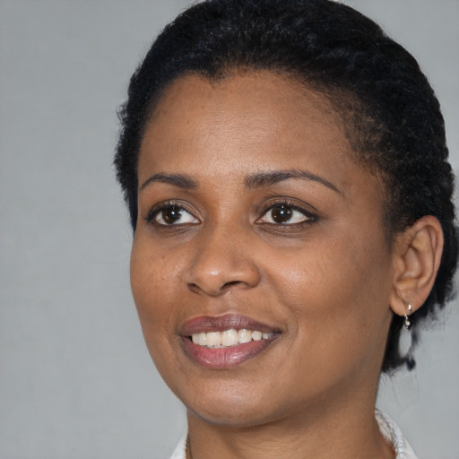 Joyful black young-adult female with short  black hair and brown eyes