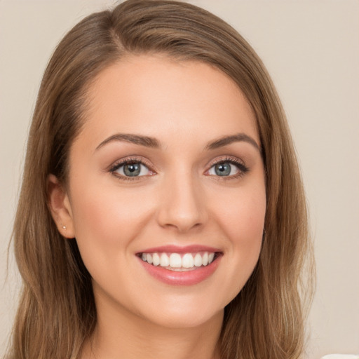 Joyful white young-adult female with long  brown hair and green eyes