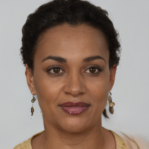 Joyful black young-adult female with short  brown hair and brown eyes