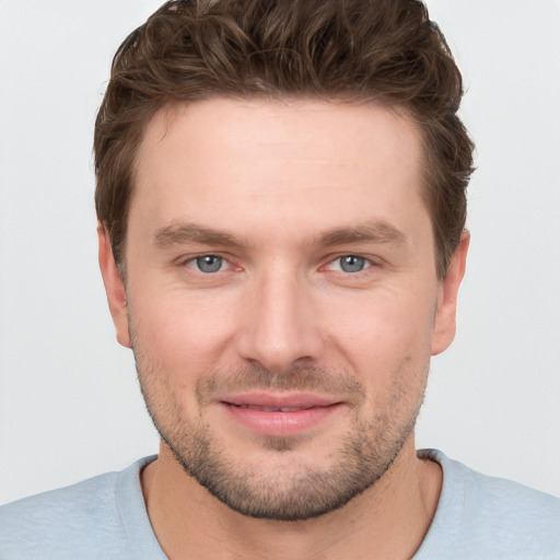 Joyful white young-adult male with short  brown hair and grey eyes